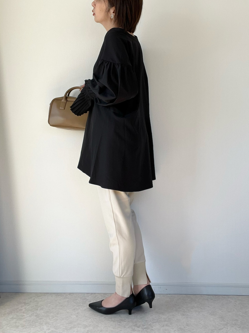 ブラック系のシャツ/ブラウス、ブラウン系のショルダーバッグ、ブラック系のパンプスを着用したレディースの冬コーディネートの2枚目の写真