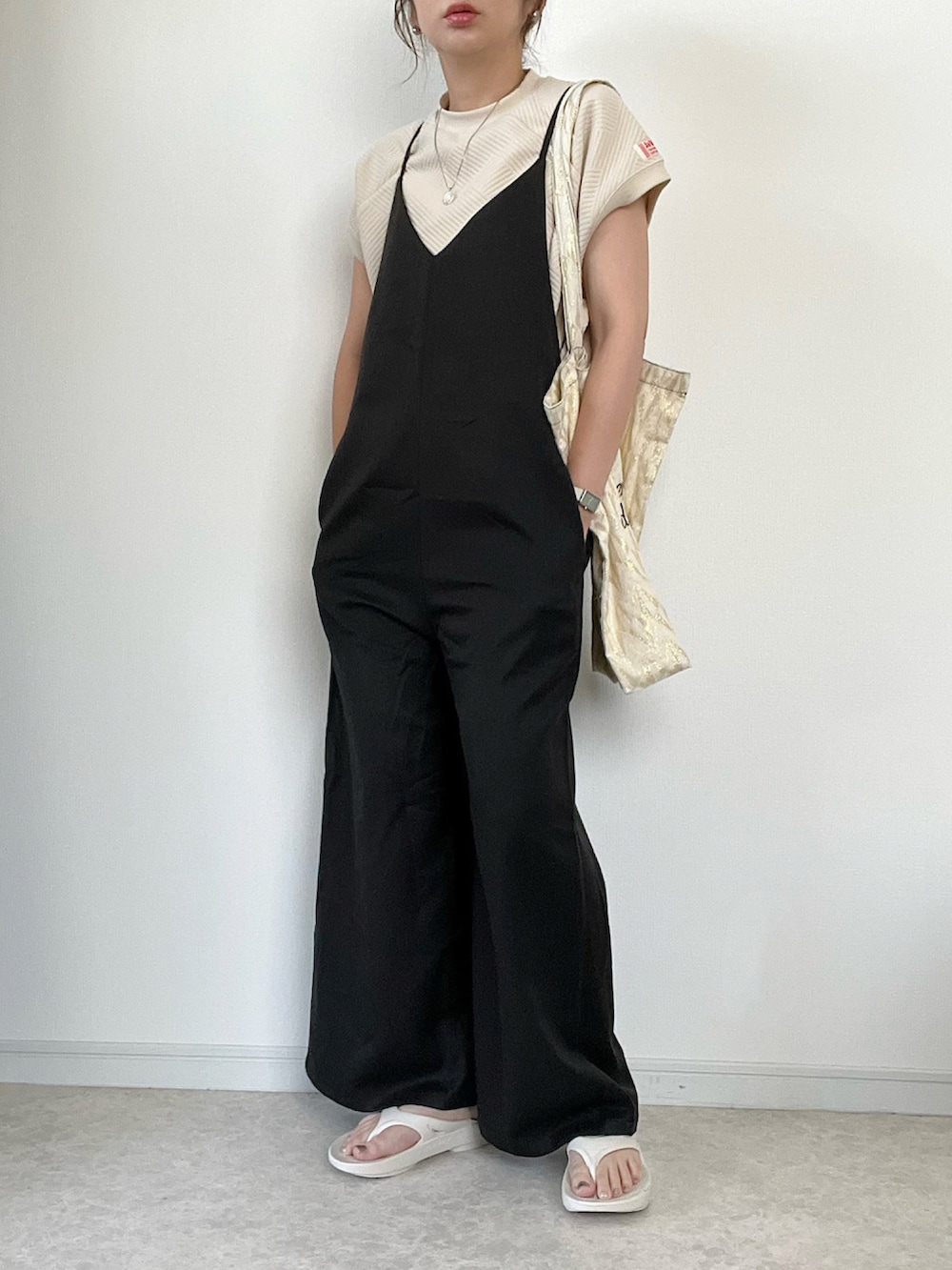 ベージュ系のTシャツ/カットソー、ベージュ系のスラックス、ブラウン系のハンドバッグを着用したレディースの夏コーディネートの3枚目の写真