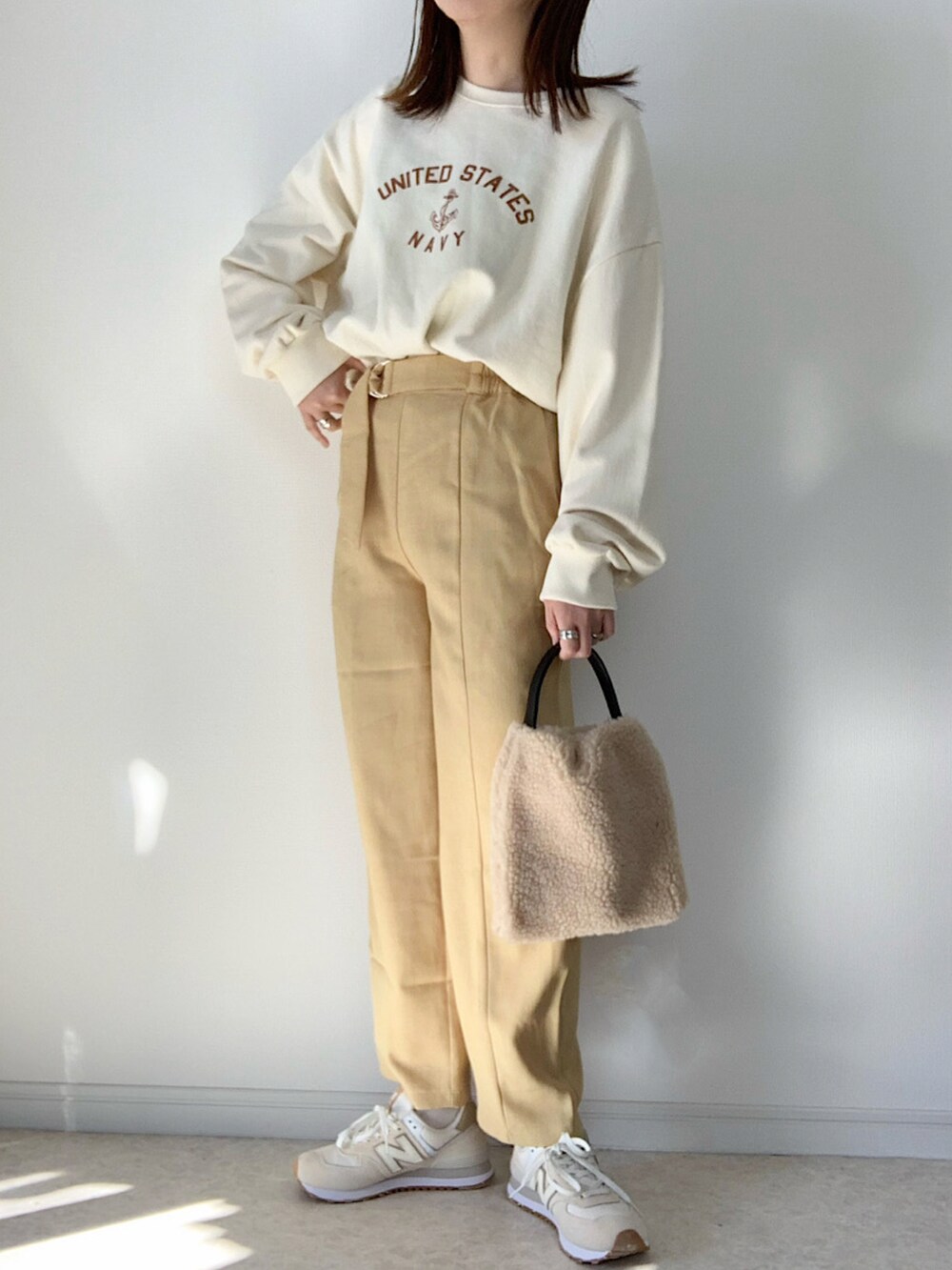 ホワイト系のニット/セーター、ブラック系のハンドバッグ、ブラック系のバレエシューズを着用したレディースの冬コーディネートの2枚目の写真