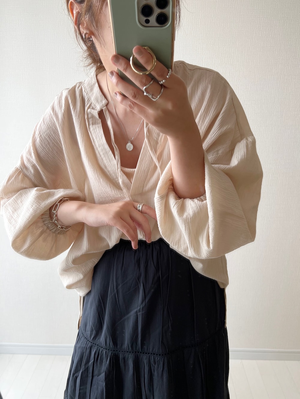 ベージュ系のシャツ/ブラウス、ブラック系のスカート、ホワイト系のサンダルを着用したレディースの夏コーディネートの2枚目の写真