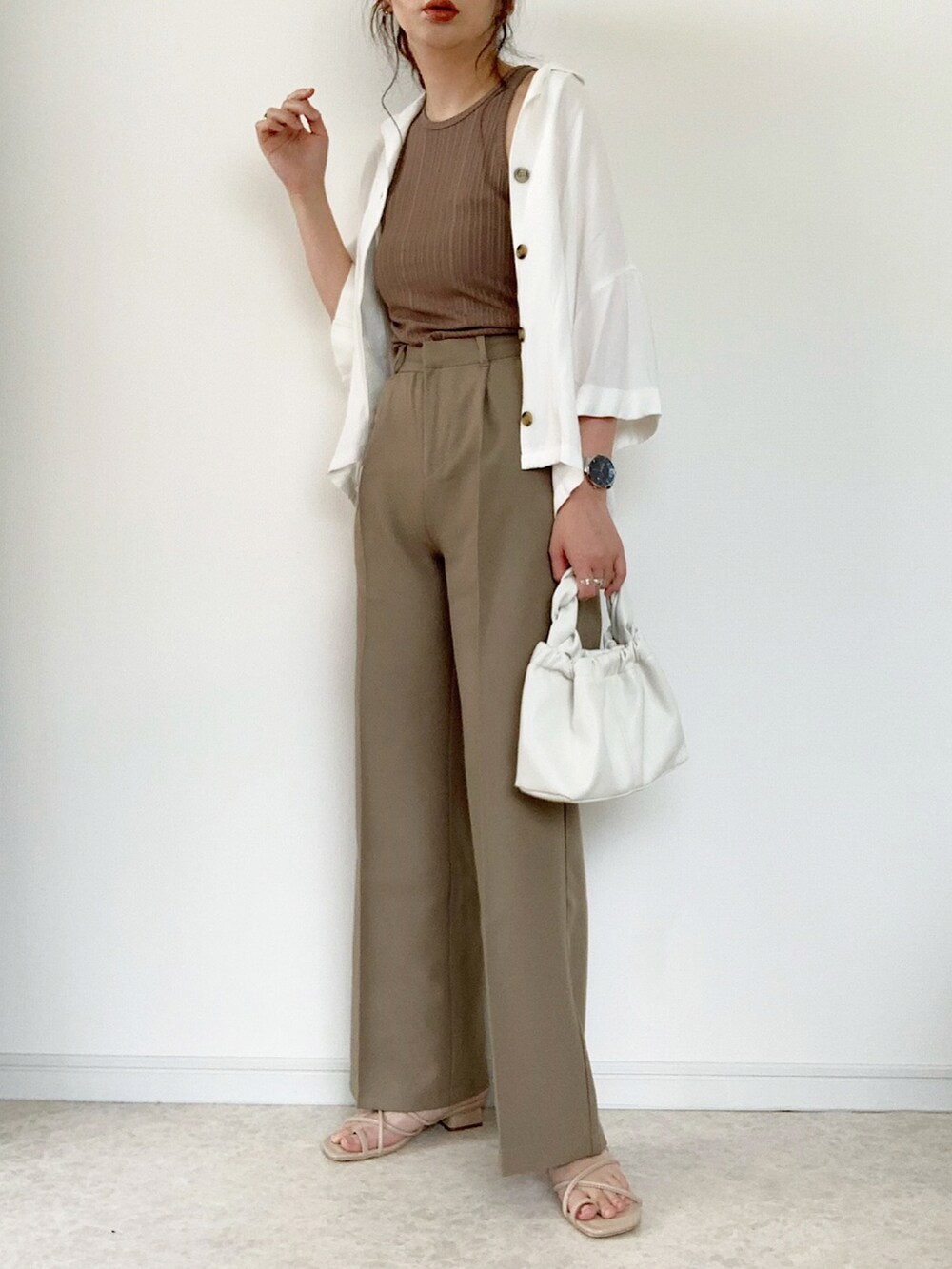 ベージュ系のTシャツ/カットソー、ブラウン系のスラックス、ベージュ系のサンダルを着用したレディースの夏コーディネートの5枚目の写真