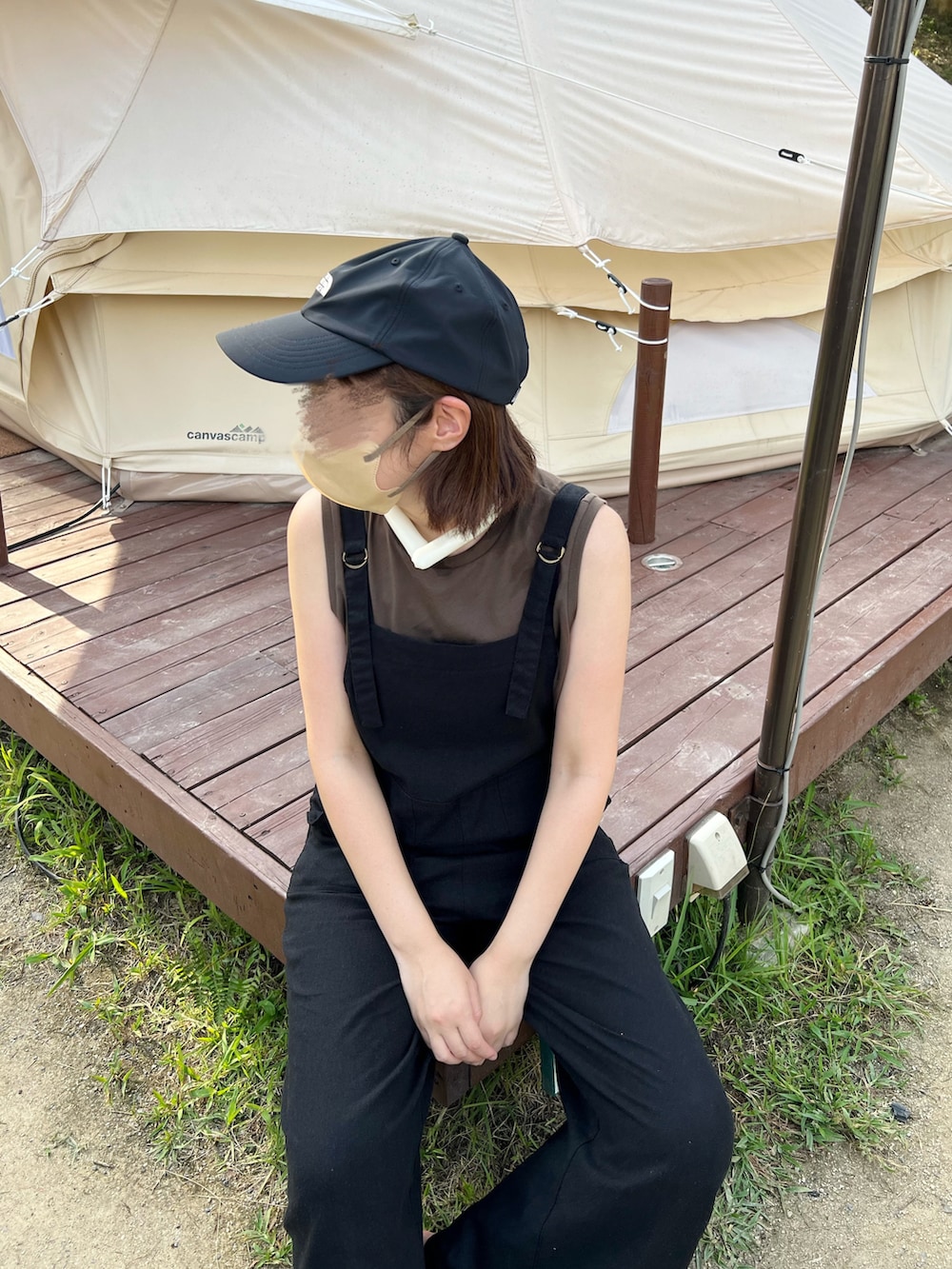 ブラック系のサロペット/オーバーオール、ブラック系のサンダル、ブラウン系のTシャツ/カットソーを着用したレディースの夏コーディネートの2枚目の写真