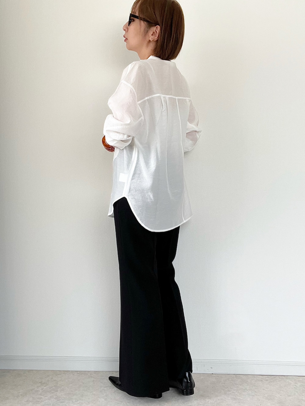 ホワイト系のシャツ/ブラウス、ブラック系のパンツ、ホワイト系のショルダーバッグを着用したレディースの春コーディネートの2枚目の写真