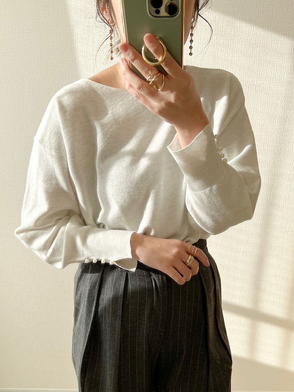 ホワイト系のニット/セーター、ブラウン系のパンツ、ブラック系のバッグを着用したレディースの冬コーディネートの3枚目の写真