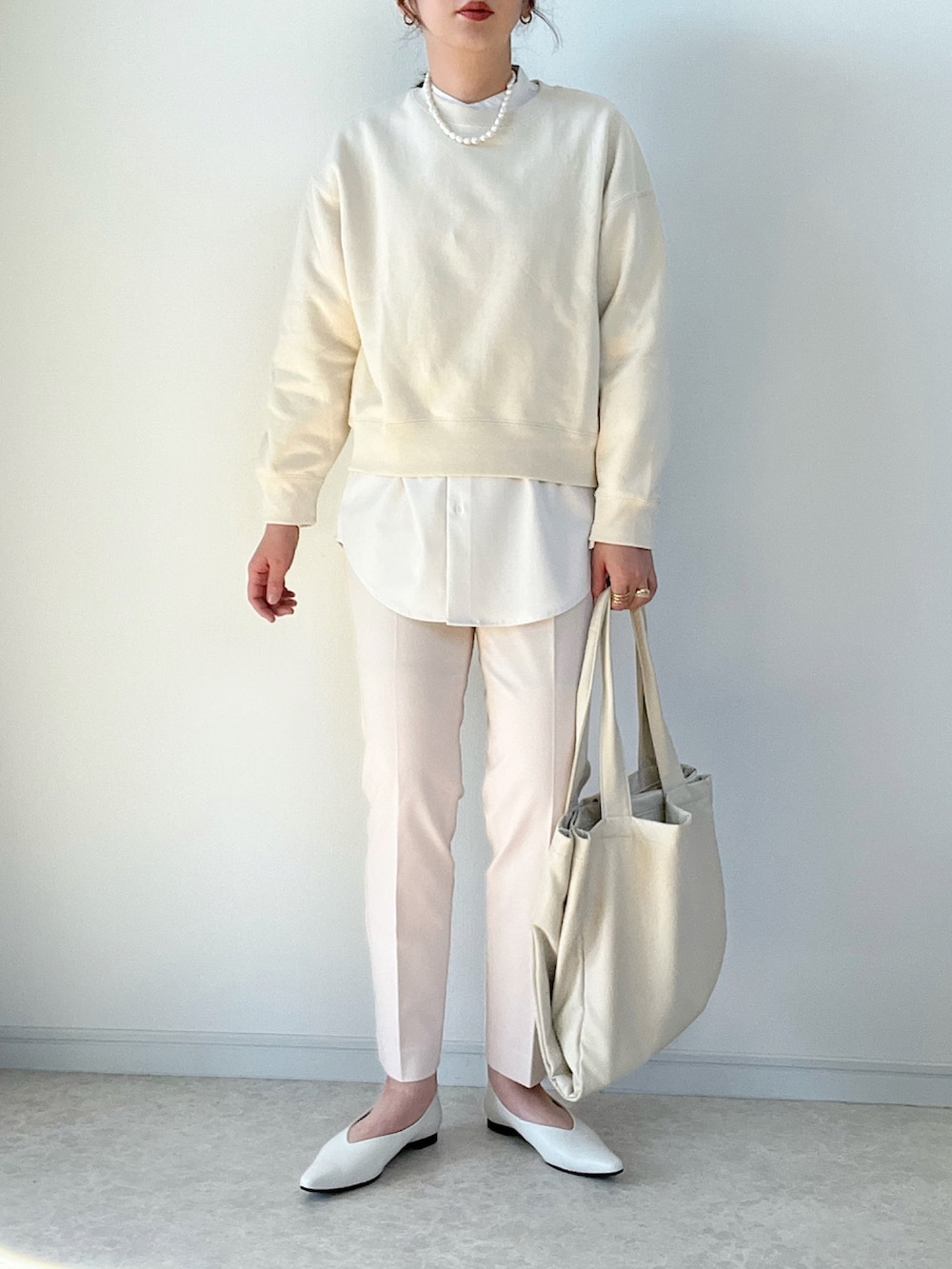 ブラック系のボストンバッグ、ブラック系のパンプス、ベージュ系のパンツを着用したレディースの冬コーディネートの4枚目の写真