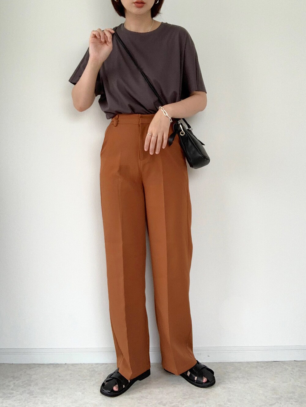 ホワイト系のTシャツ/カットソー、ブラウン系のスラックス、ホワイト系のショルダーバッグを着用したレディースの夏コーディネートの2枚目の写真