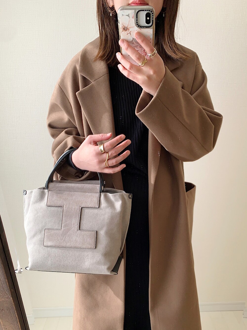 ベージュ系のチェスターコート、ホワイト系のニット/セーター、ホワイト系のTシャツ/カットソーを着用したレディースの冬コーディネートの4枚目の写真