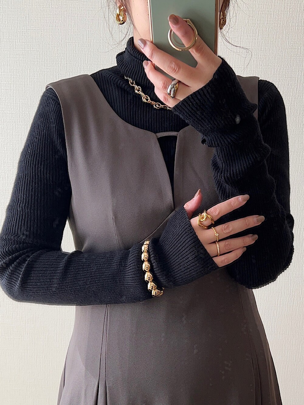 ブラウン系のカーディガン/ボレロ、ブラック系のニット/セーター、グレー系のワンピース/ドレスを着用したレディースの冬コーディネートの2枚目の写真