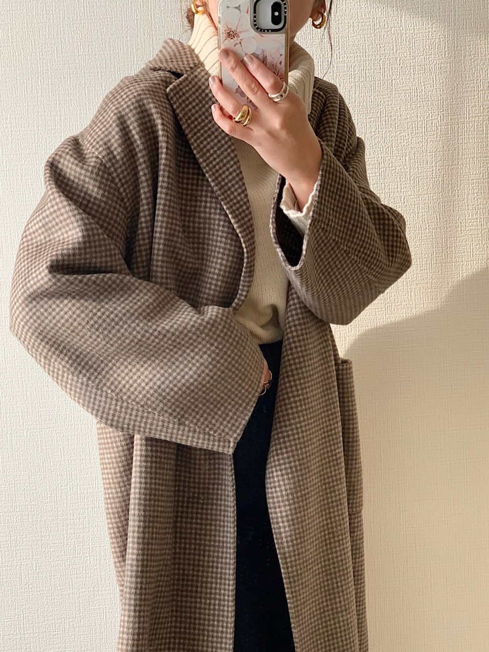 ブラウン系のチェスターコート、ホワイト系のセットアップ、ブラウン系のブーツを着用したレディースの秋コーディネートの2枚目の写真