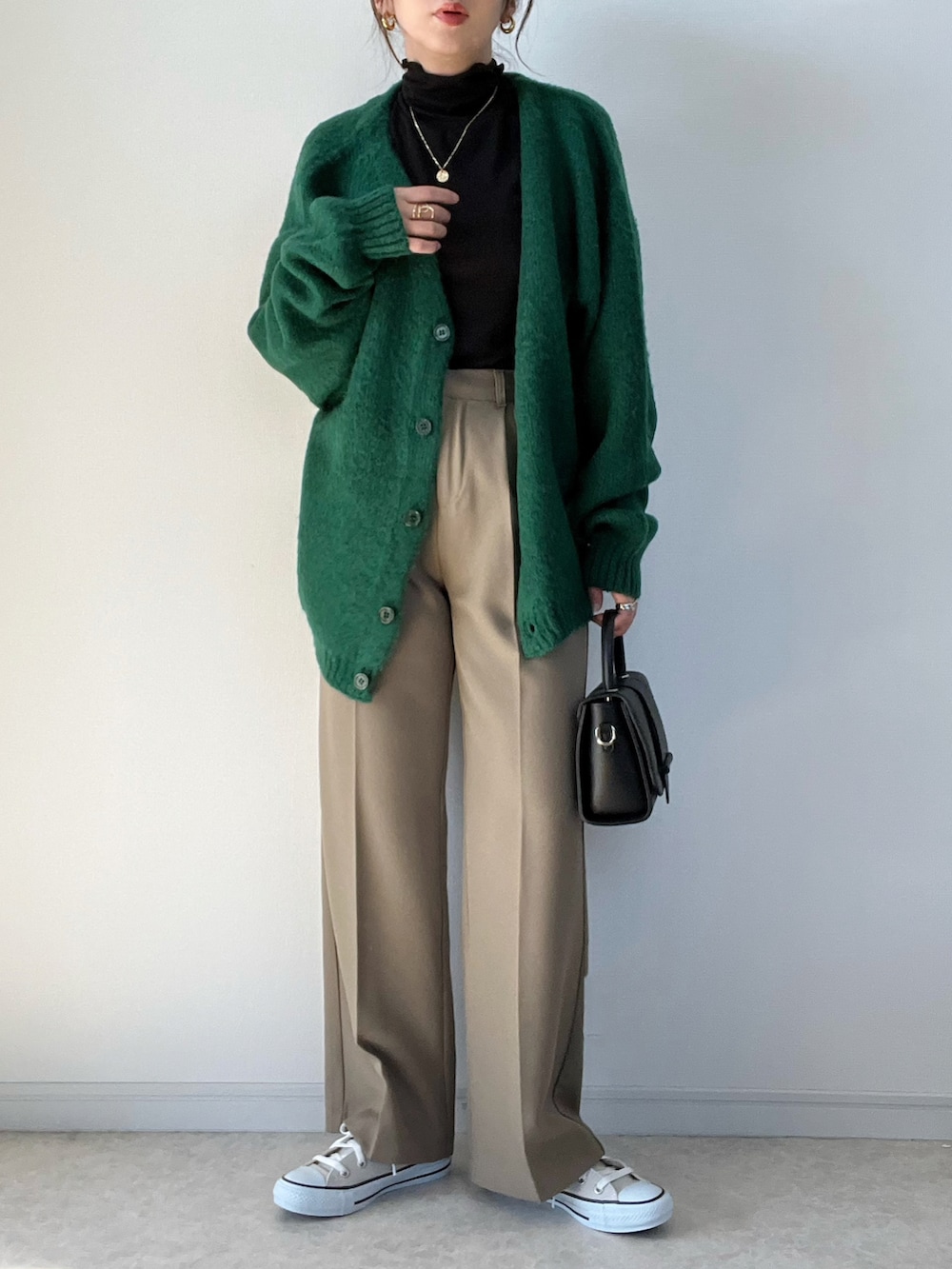 グリーン系のカーディガン/ボレロ、ホワイト系のTシャツ/カットソー、グレー系のスニーカーを着用したレディースの秋コーディネートの2枚目の写真