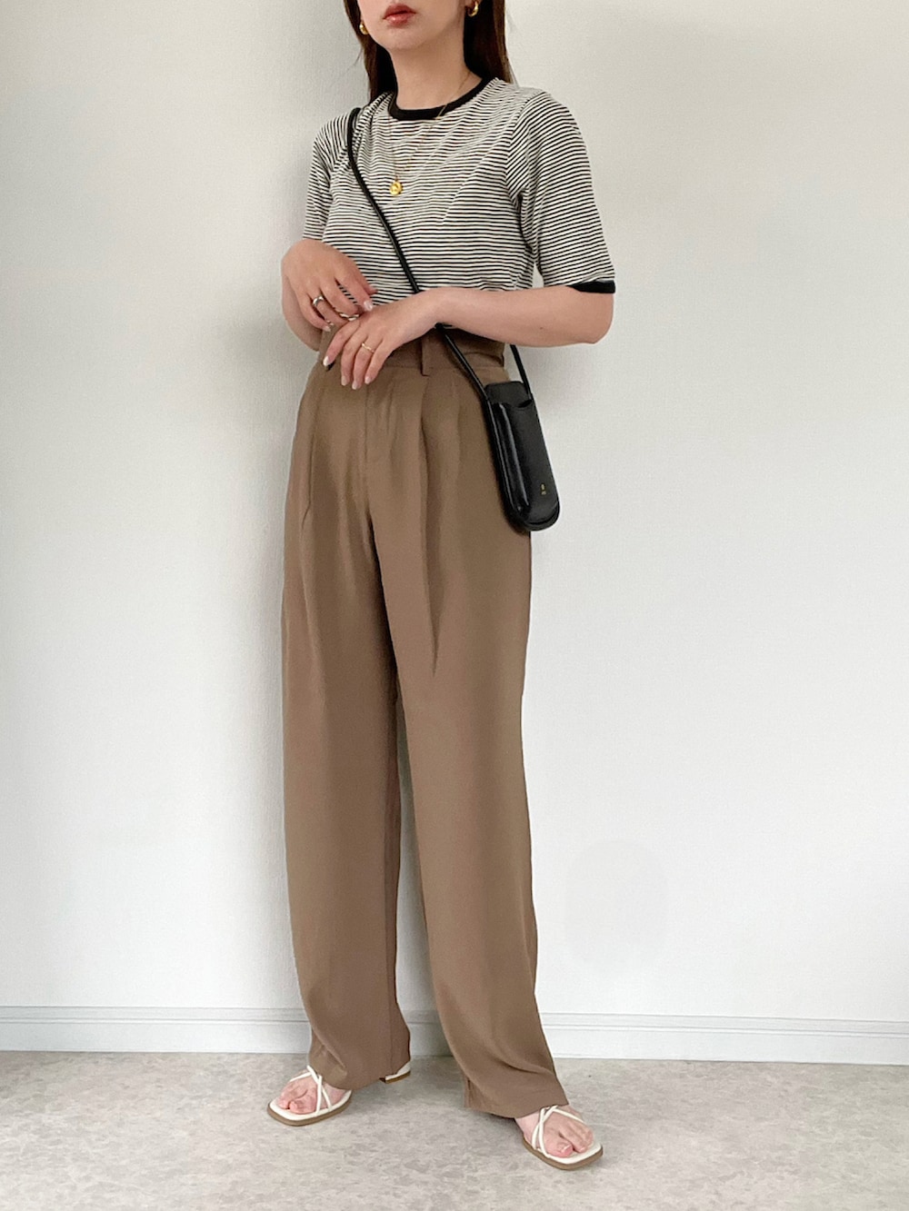 ベージュ系のTシャツ/カットソー、ブラウン系のスラックス、ブラウン系のサンダルを着用したレディースの春コーディネートの2枚目の写真