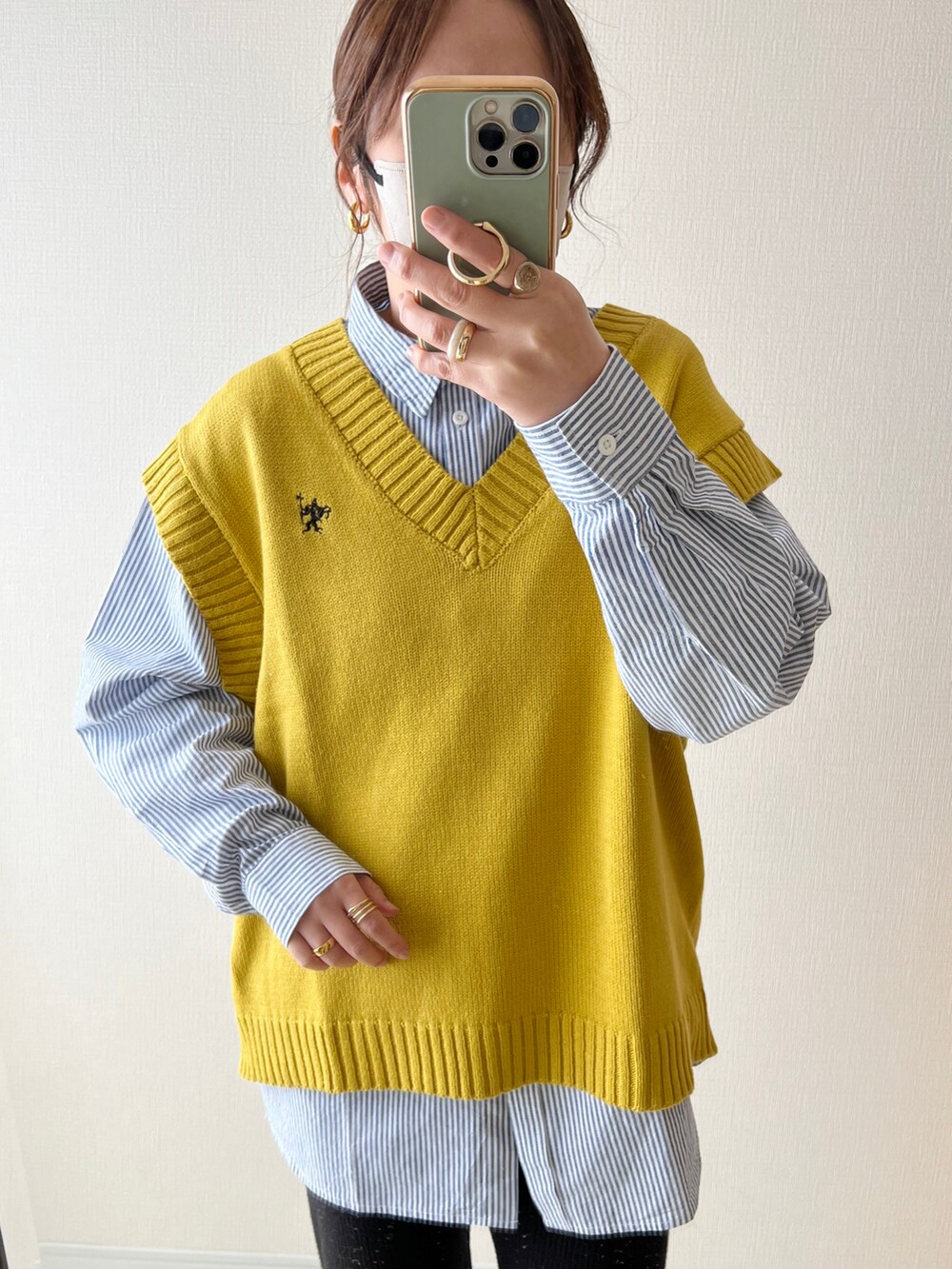 イエロー系のベスト、ブルー系のシャツ/ブラウス、ブラック系のその他パンツを着用したレディースの冬コーディネートの2枚目の写真