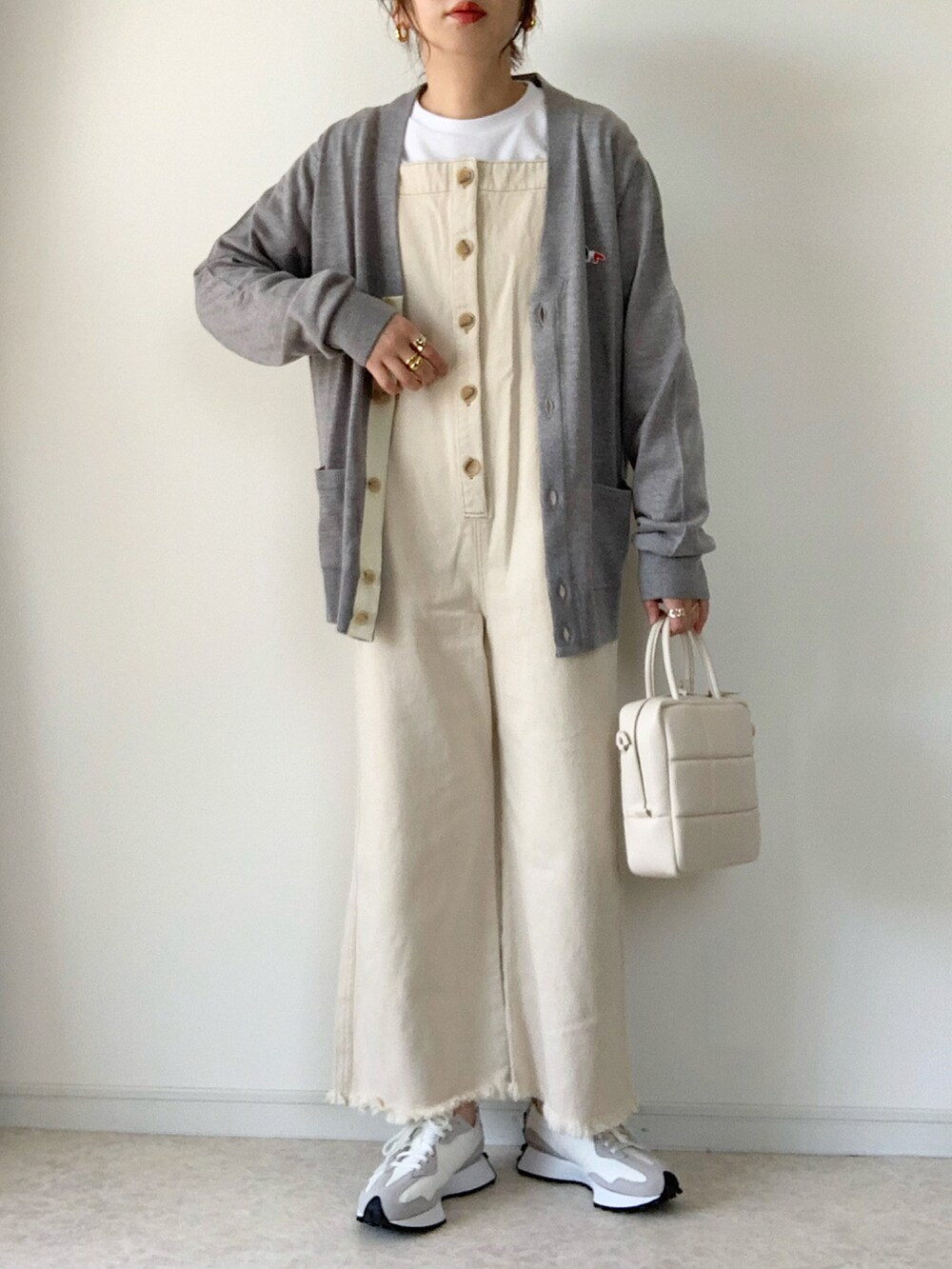 ブラック系のナイロンジャケット、ベージュ系のサロペット/オーバーオール、ホワイト系のトートバッグを着用したレディースの春コーディネートの3枚目の写真