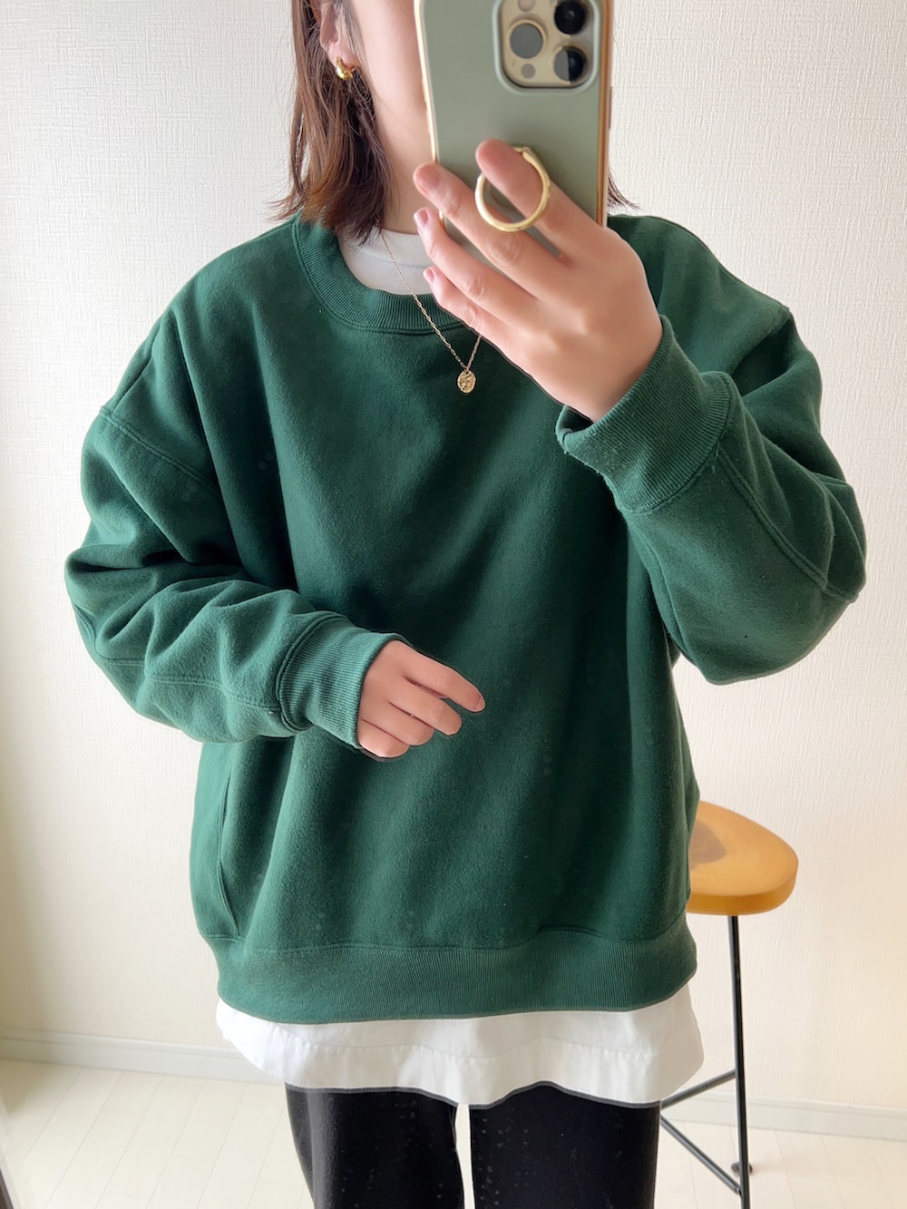 グリーン系のスウェット、ブラック系のその他パンツ、ホワイト系のショルダーバッグを着用したレディースの冬コーディネートの2枚目の写真