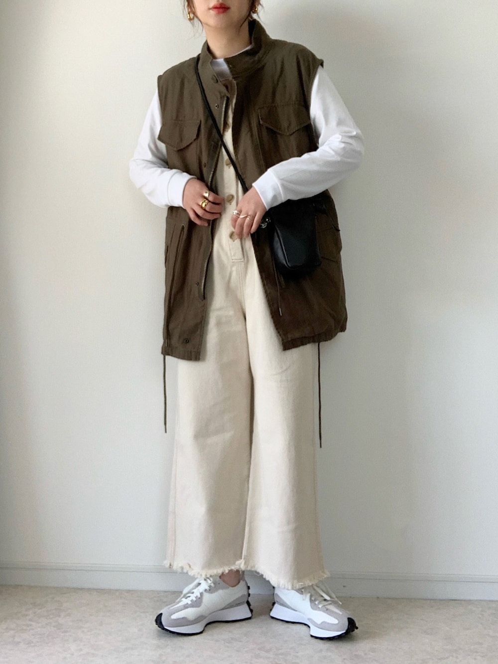 ブラック系のナイロンジャケット、ベージュ系のサロペット/オーバーオール、ホワイト系のトートバッグを着用したレディースの春コーディネートの2枚目の写真