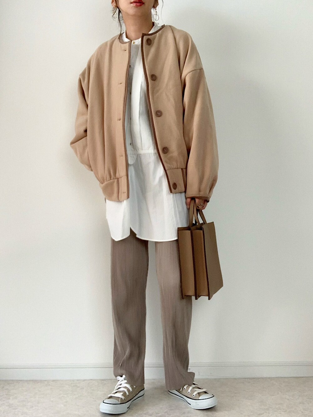 ベージュ系のカーディガン/ボレロ、ブラック系のTシャツ/カットソー、ホワイト系のデニムパンツを着用したレディースの秋コーディネートの4枚目の写真