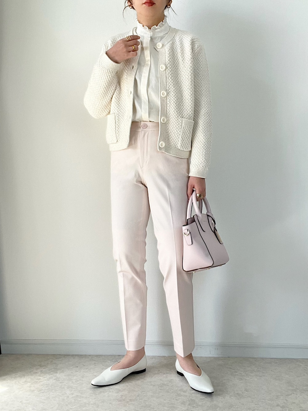 ブラック系のボストンバッグ、ブラック系のパンプス、ベージュ系のパンツを着用したレディースの冬コーディネートの3枚目の写真