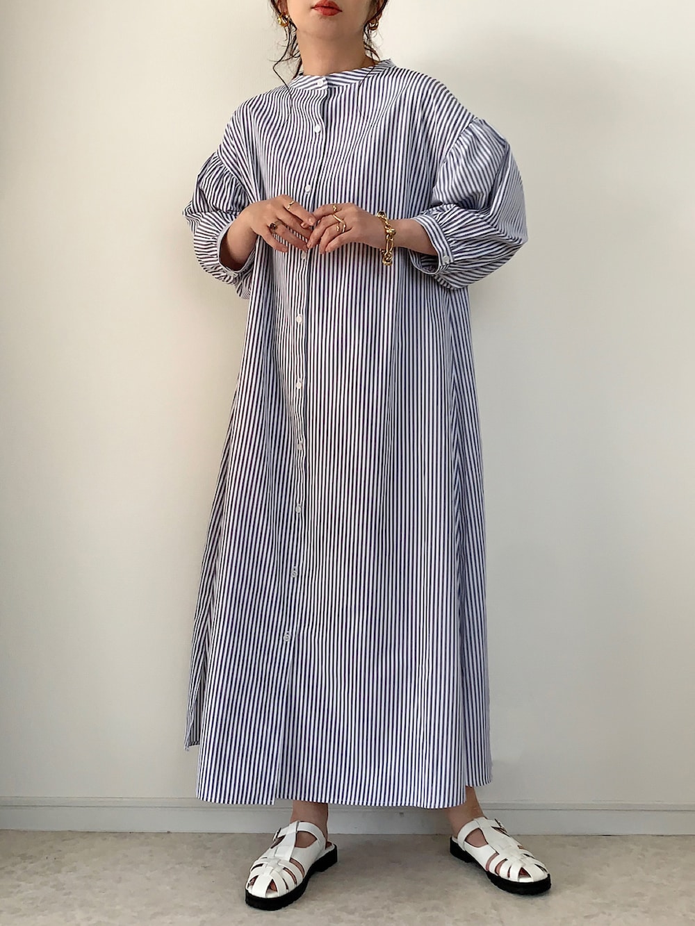 グレー系のベスト、グレー系のシャツワンピース、ホワイト系のトートバッグを着用したレディースの春コーディネートの3枚目の写真