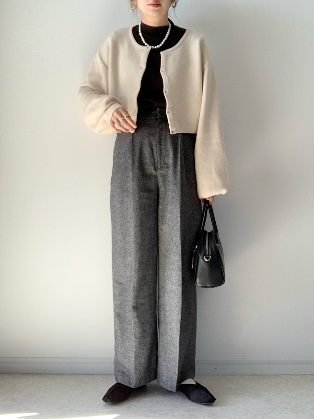 ホワイト系のカーディガン/ボレロ、グレー系のその他パンツ、ブラック系のその他シューズを着用したレディースの秋コーディネートの2枚目の写真