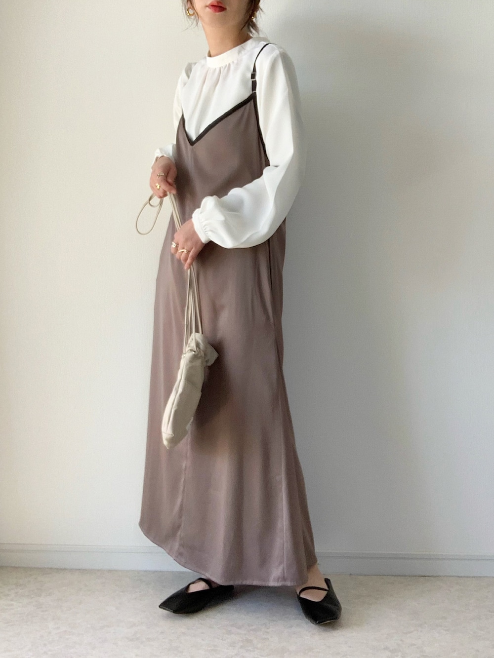 ベージュ系のトレンチコート、グレー系のワンピース、ホワイト系のシャツ/ブラウスを着用したレディースの冬コーディネートの2枚目の写真