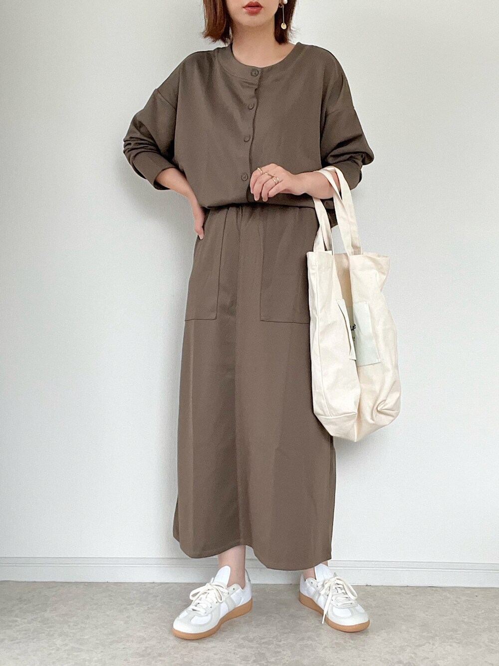 ブラック系のバッグ、ホワイト系のスニーカー、ブラウン系のカーディガン/ボレロを着用したレディースの夏コーディネートの3枚目の写真