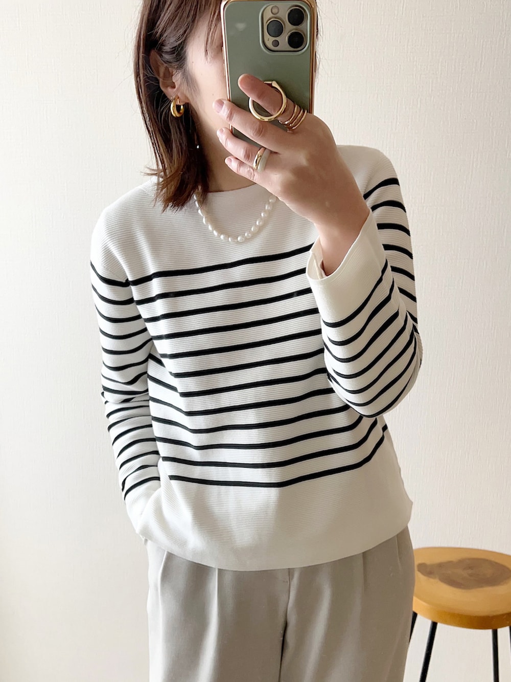 ホワイト系のニット/セーター、ベージュ系のその他パンツ、ブラック系のボストンバッグを着用したレディースの冬コーディネートの2枚目の写真