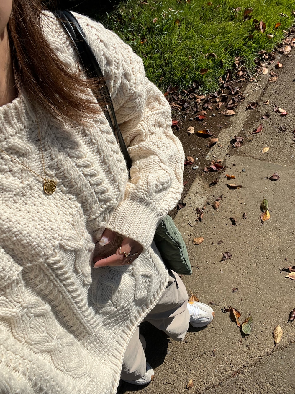 ホワイト系のニット/セーター、ベージュ系のチノパンツ、グリーン系のトートバッグを着用したレディースの秋コーディネートの2枚目の写真