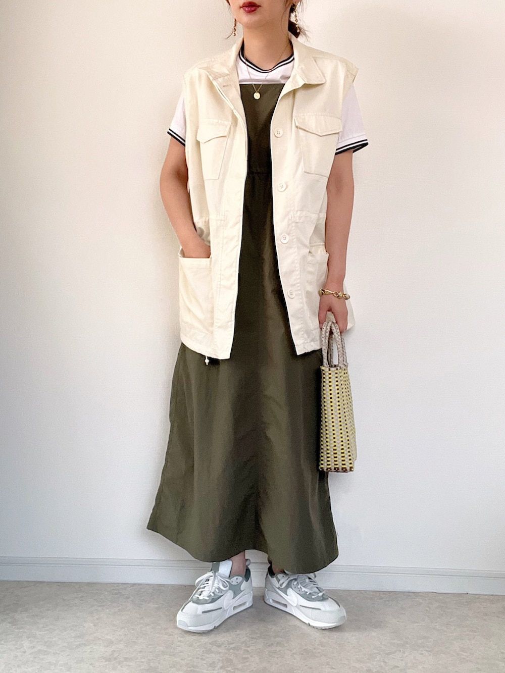 ホワイト系のカーディガン/ボレロ、グリーン系のワンピース、グレー系のスニーカーを着用したレディースの春コーディネートの2枚目の写真