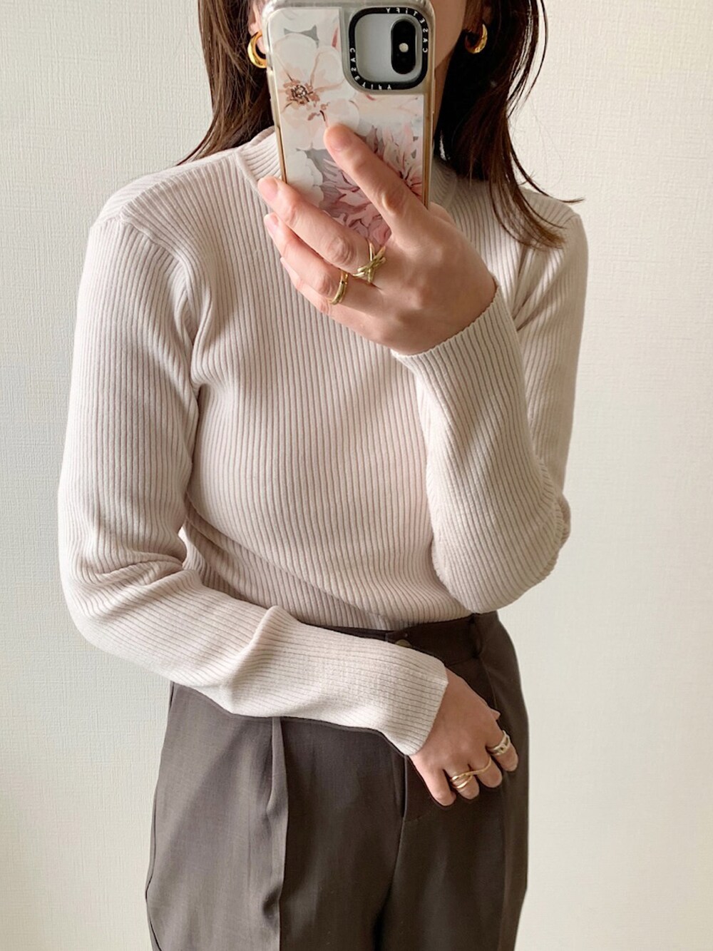 ベージュ系のカーディガン/ボレロ、ブラウン系のスラックス、ホワイト系のニット/セーターを着用したレディースの冬コーディネートの2枚目の写真