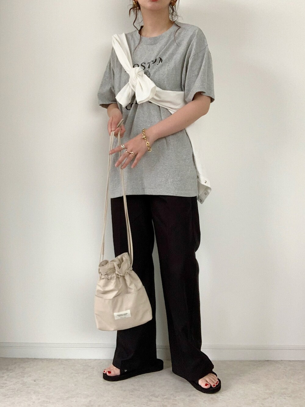 グレー系のTシャツ/カットソー、グリーン系のスニーカー、ブラック系のショルダーバッグを着用したレディースの夏コーディネートの2枚目の写真