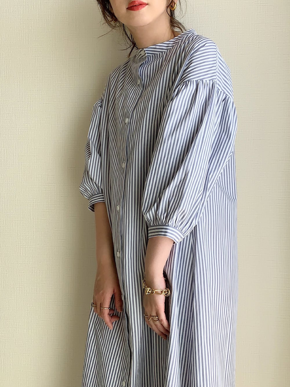 グレー系のベスト、グレー系のシャツワンピース、ホワイト系のトートバッグを着用したレディースの春コーディネートの2枚目の写真