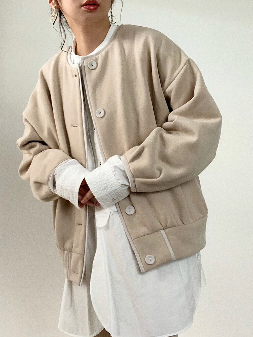 ベージュ系のカーディガン/ボレロ、ブルー系のデニムパンツ、ブラウン系のバッグを着用したレディースの秋コーディネートの3枚目の写真