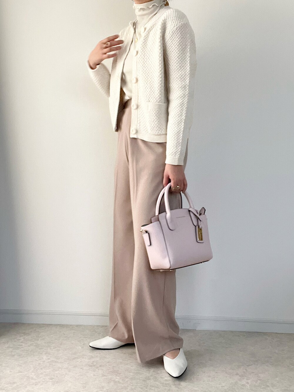 ベージュ系のスーツセット、ホワイト系のシャツワンピース、ホワイト系のパンプスを着用したレディースの冬コーディネートの2枚目の写真