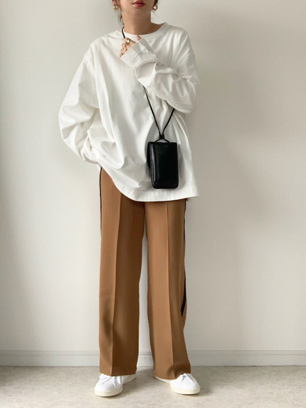 ブラック系のダウンベスト、イエロー系のその他パンツ、ホワイト系のスニーカーを着用したレディースの秋コーディネートの2枚目の写真