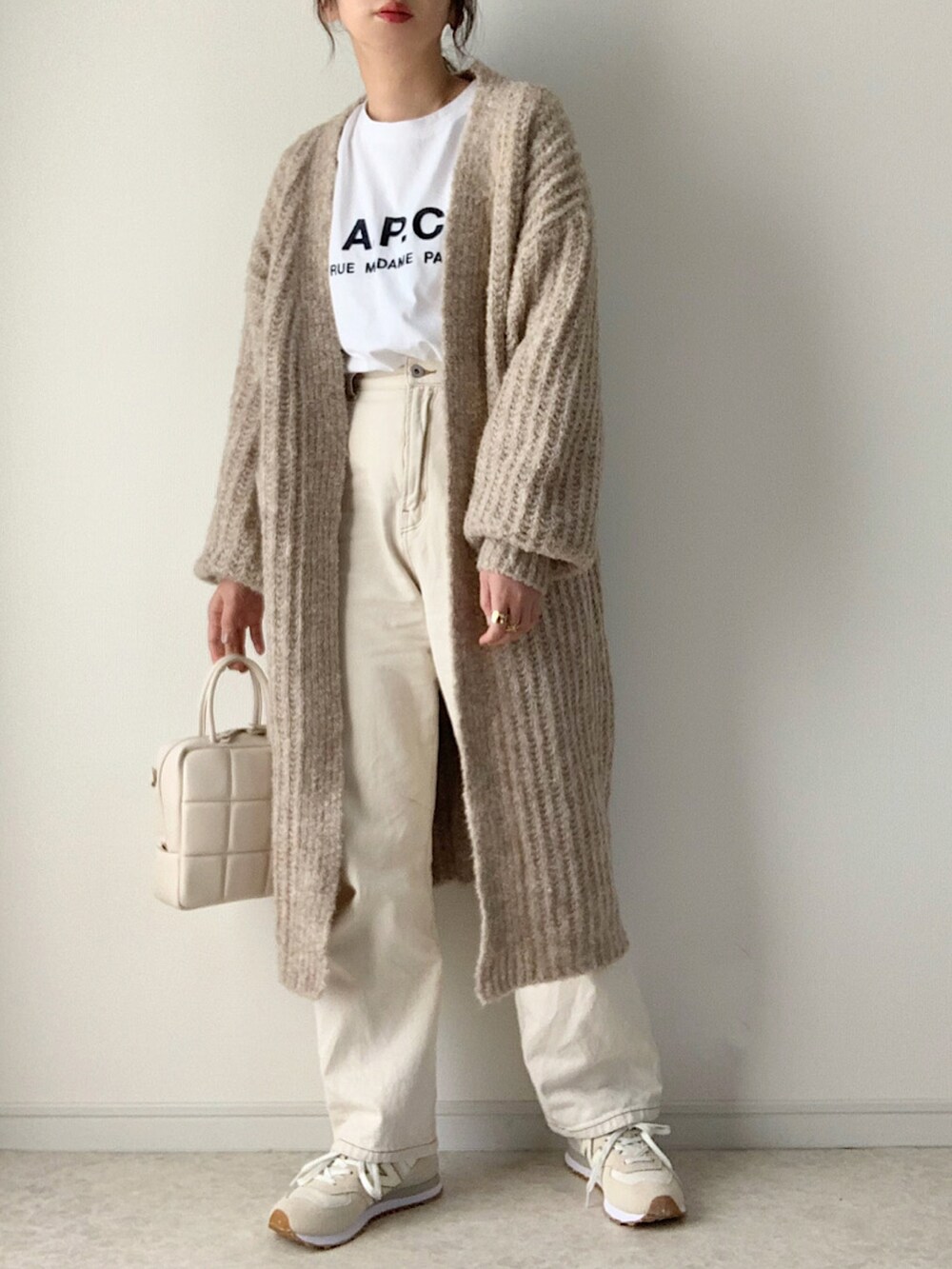 ベージュ系のカーディガン/ボレロ、ホワイト系のTシャツ/カットソー、ホワイト系のデニムパンツを着用したレディースの冬コーディネートの2枚目の写真