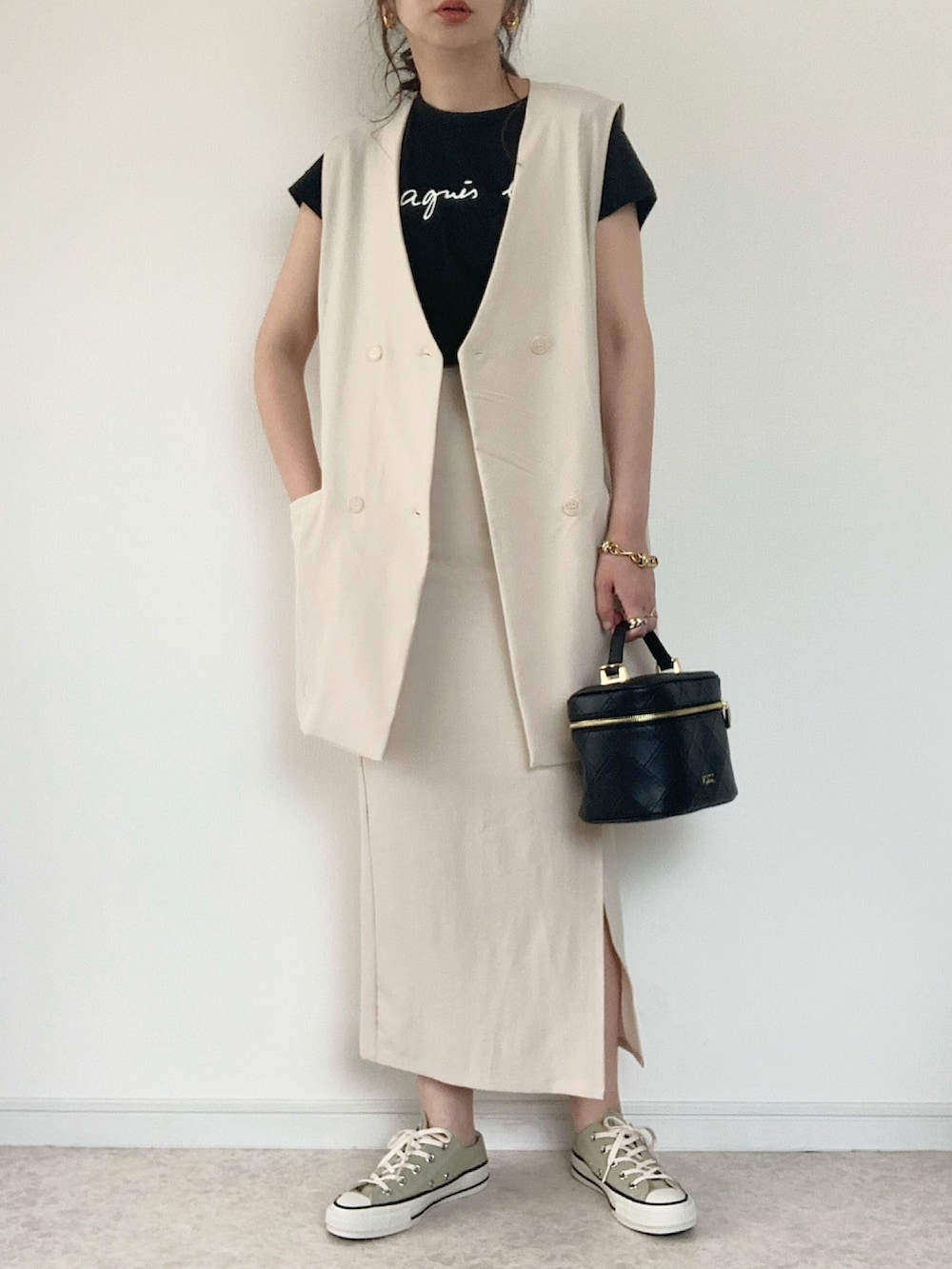 ホワイト系のテーラードジャケット、ホワイト系のスカート、ブラック系のサンダルを着用したレディースの春コーディネートの2枚目の写真