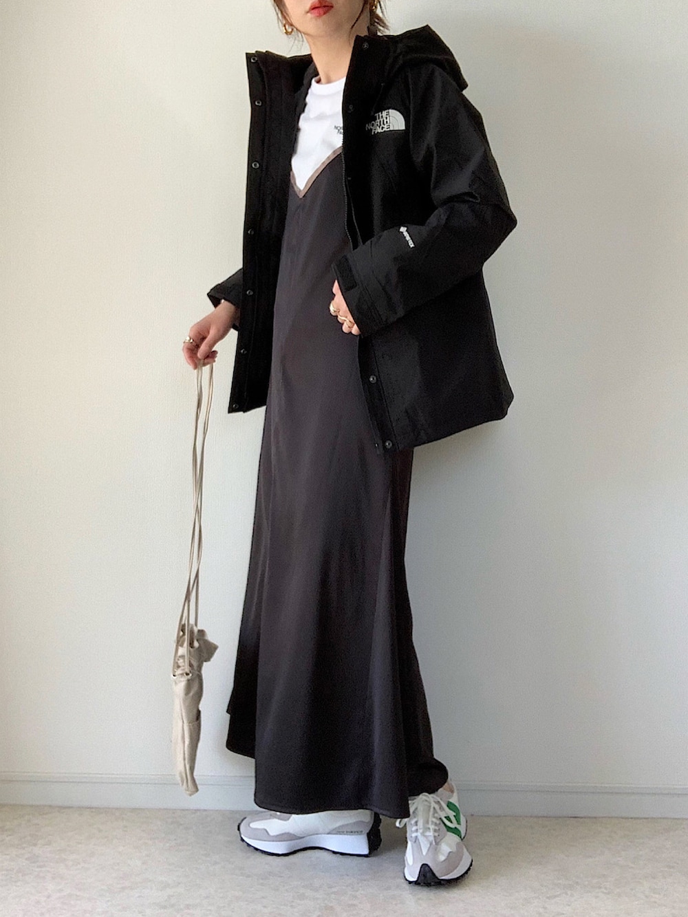 ホワイト系のTシャツ/カットソー、ブラック系のワンピース、ベージュ系のショルダーバッグを着用したレディースの春コーディネートの2枚目の写真