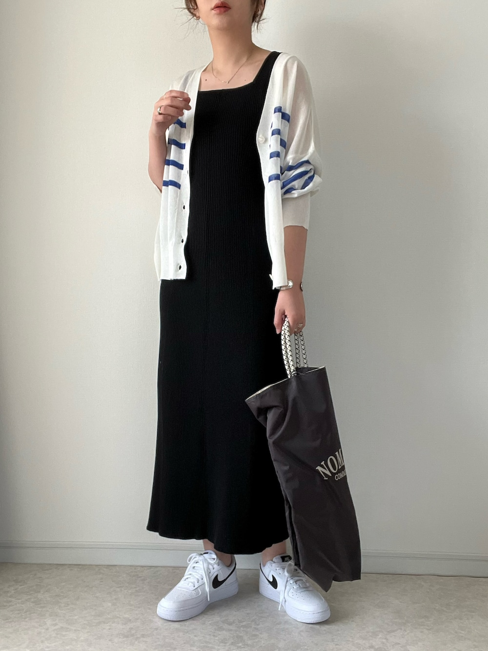 ホワイト系のカーディガン/ボレロ、ブラック系のワンピース/ドレス、ホワイト系のスニーカーを着用したレディースの春コーディネートの3枚目の写真