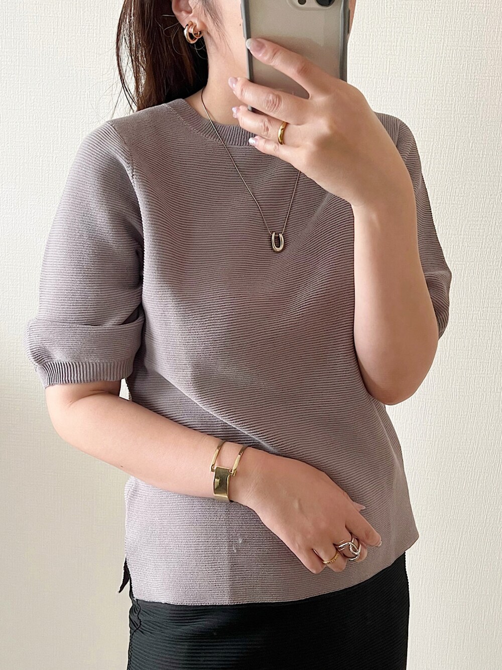 グレー系のニット/セーター、ブラウン系のスラックス、ブラウン系のハンドバッグを着用したレディースの夏コーディネートの2枚目の写真