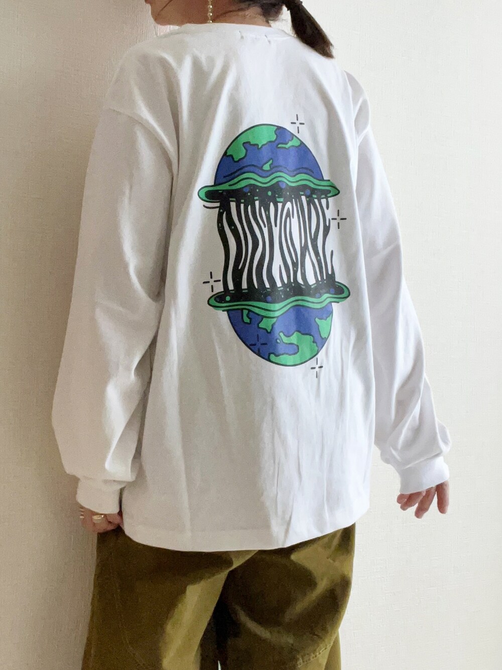 グリーン系のスラックス、ホワイト系のTシャツ/カットソーを着用したレディースの冬コーディネートの3枚目の写真