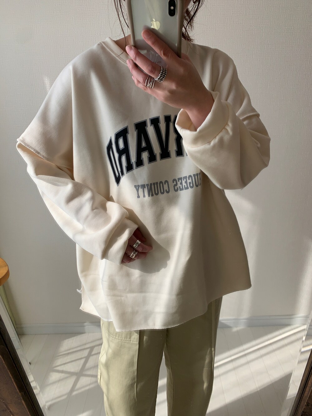 ブラック系のスカート、ブラウン系のショルダーバッグ、ベージュ系のスニーカーを着用したレディースの春コーディネートの3枚目の写真