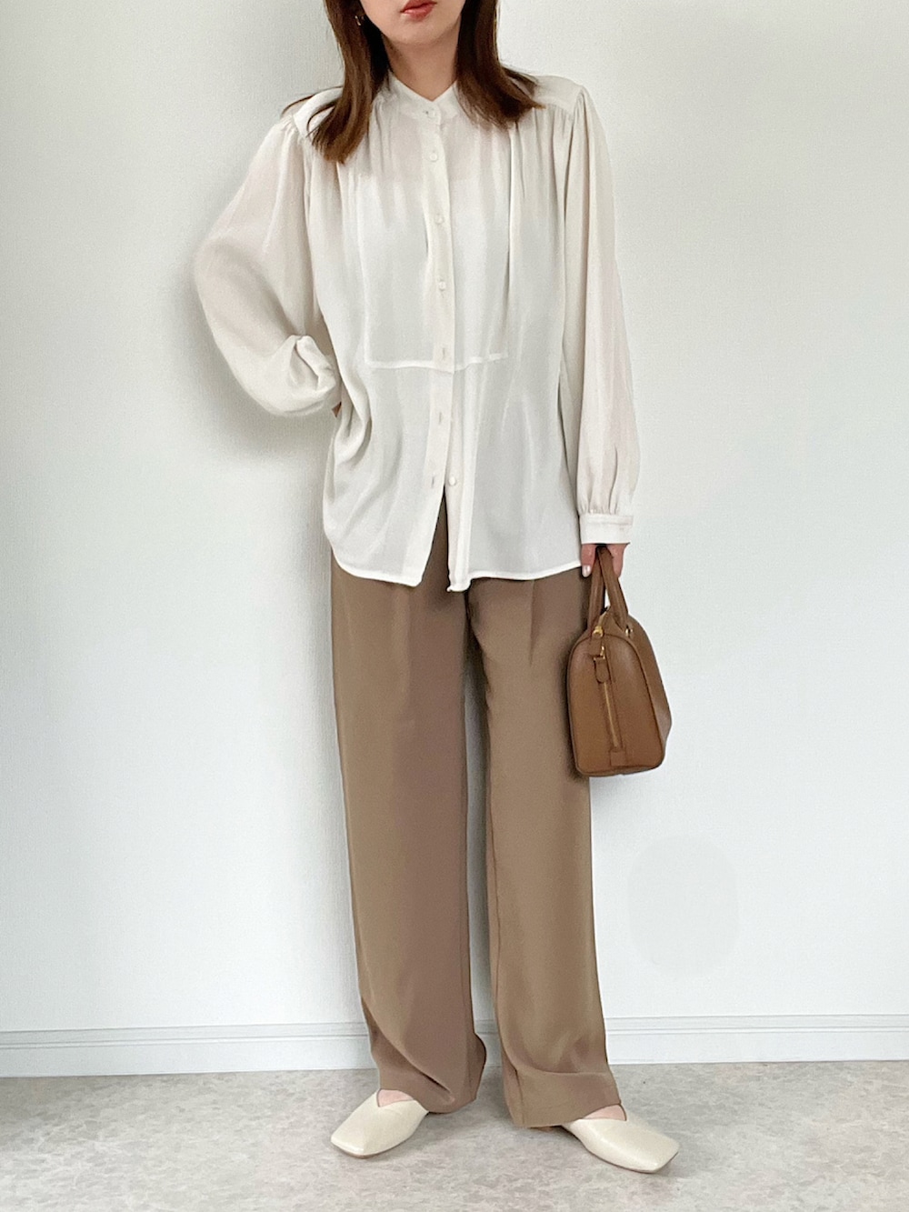 ベージュ系のTシャツ/カットソー、ブラウン系のスラックス、ブラウン系のサンダルを着用したレディースの春コーディネートの3枚目の写真