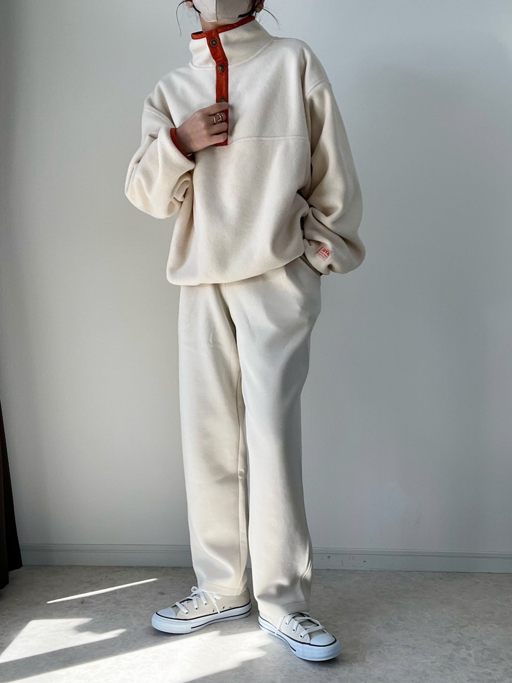 ベージュ系のスウェット、ホワイト系のパンツ、グレー系のスニーカーを着用したレディースの冬コーディネートの2枚目の写真