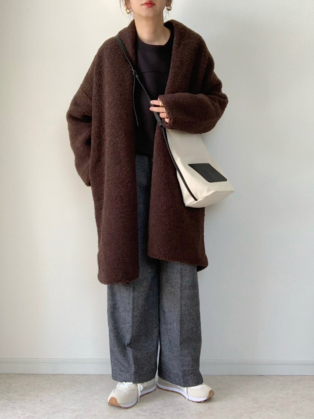 ホワイト系のスニーカー、ブラック系のショルダーバッグ、ホワイト系のTシャツ/カットソーを着用したレディースの秋コーディネートの4枚目の写真