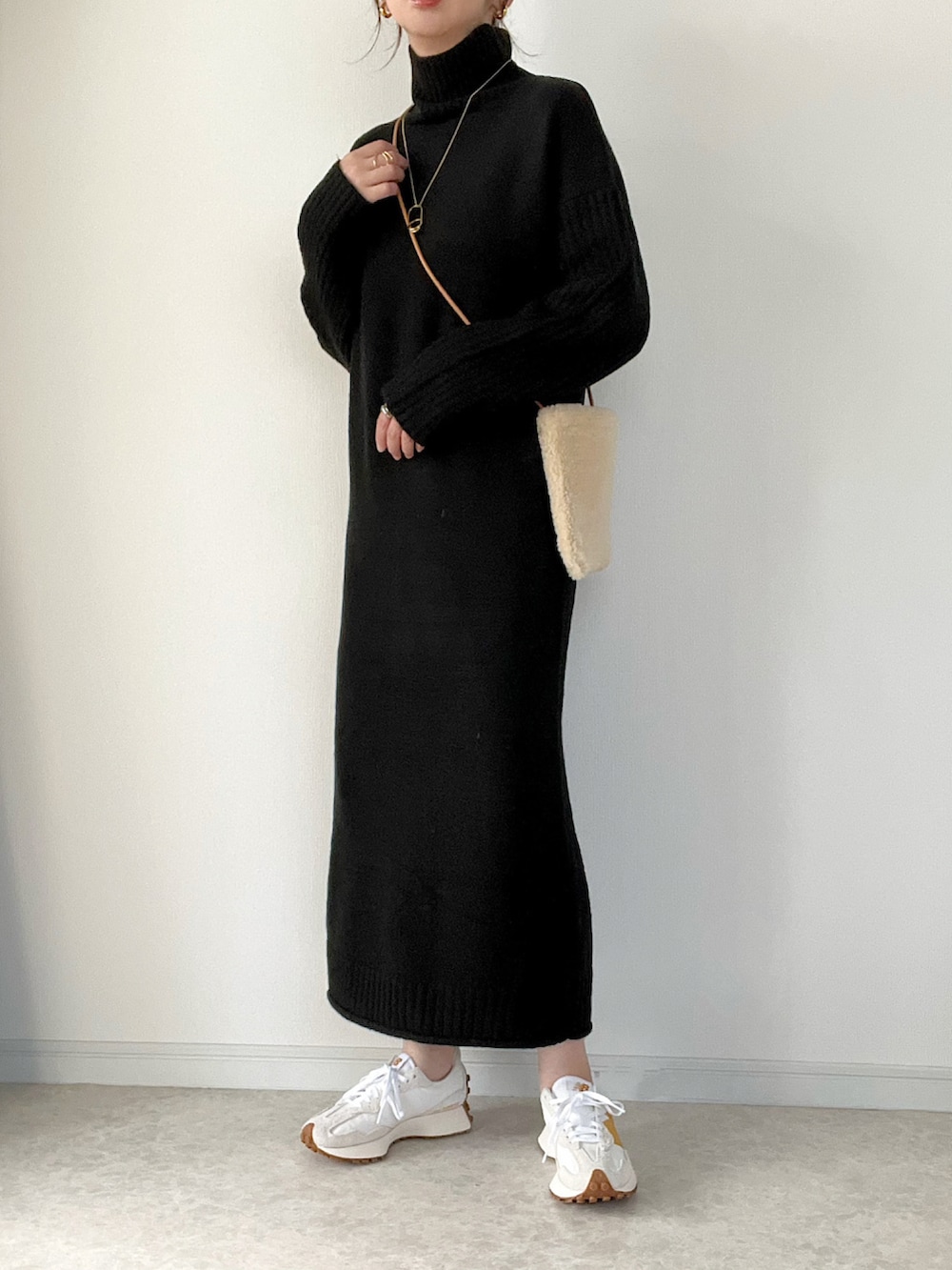 ベージュ系のノーカラージャケット、ブラック系のワンピース、ブラック系のショルダーバッグを着用したレディースの秋コーディネートの2枚目の写真