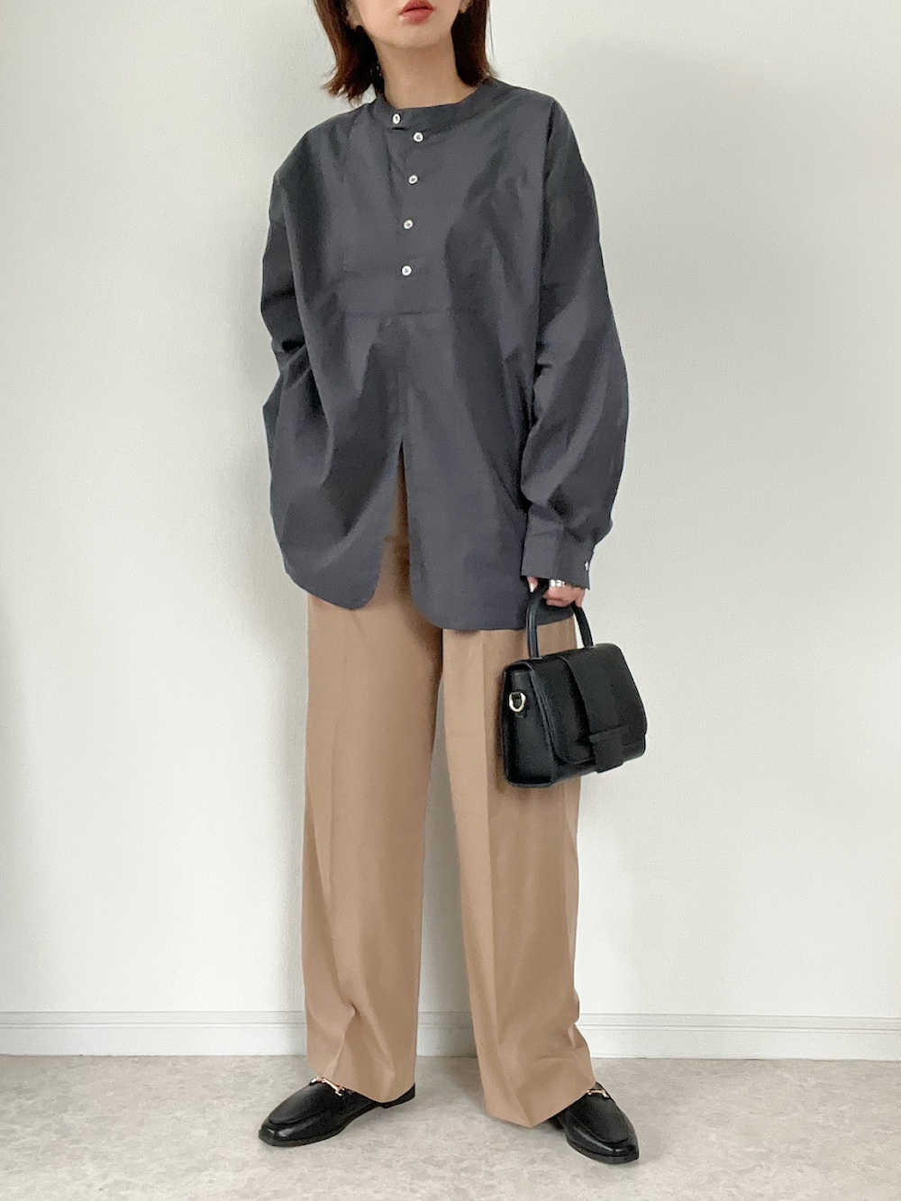 ブラック系のシャツ/ブラウス、ホワイト系のトートバッグ、ブラック系のパンプスを着用したレディースの秋コーディネートの3枚目の写真