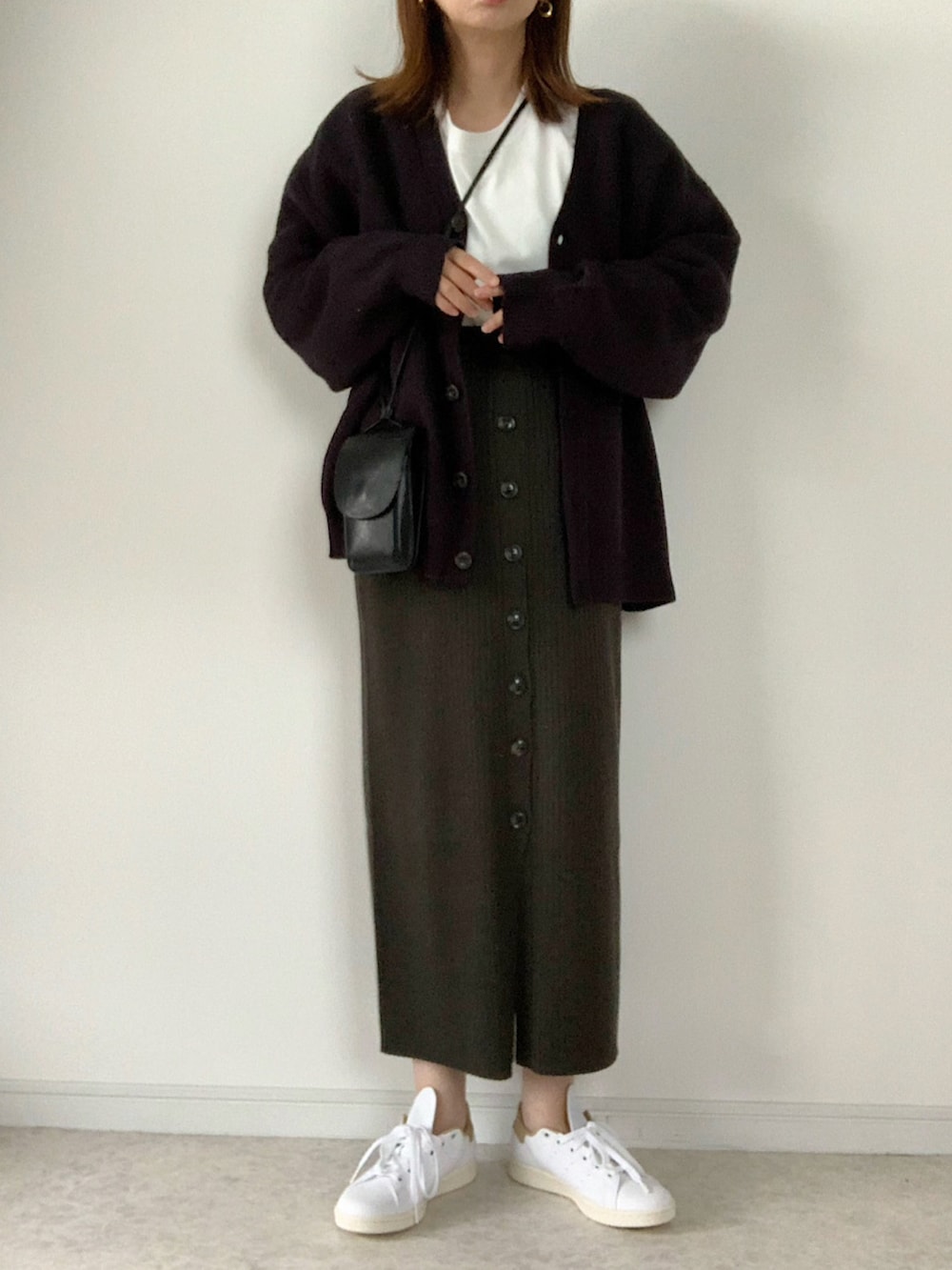 イエロー系のニット/セーター、グレー系のスカート、ホワイト系のブーツを着用したレディースの秋コーディネートの3枚目の写真