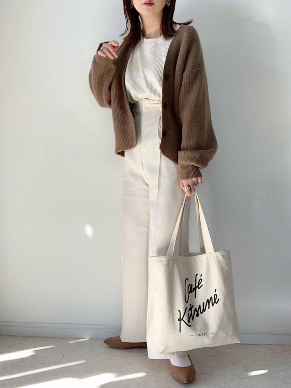 ホワイト系のパンツ、ブラック系のショルダーバッグ、ホワイト系のスニーカーを着用したレディースの冬コーディネートの2枚目の写真