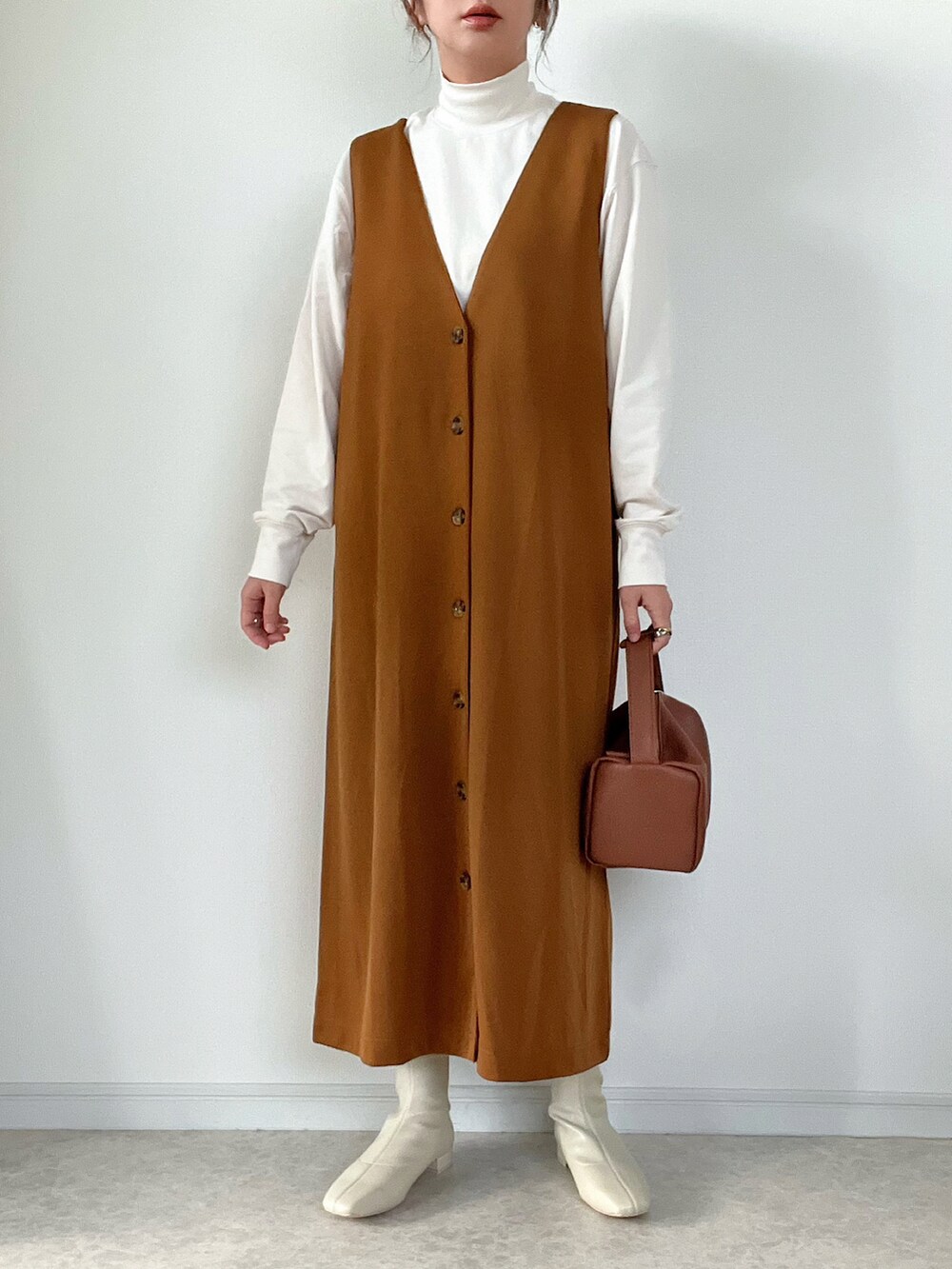 ホワイト系のジャケット/アウター、ブラウン系のサロペット/オーバーオール、ブラウン系のショルダーバッグを着用したレディースの冬コーディネートの2枚目の写真