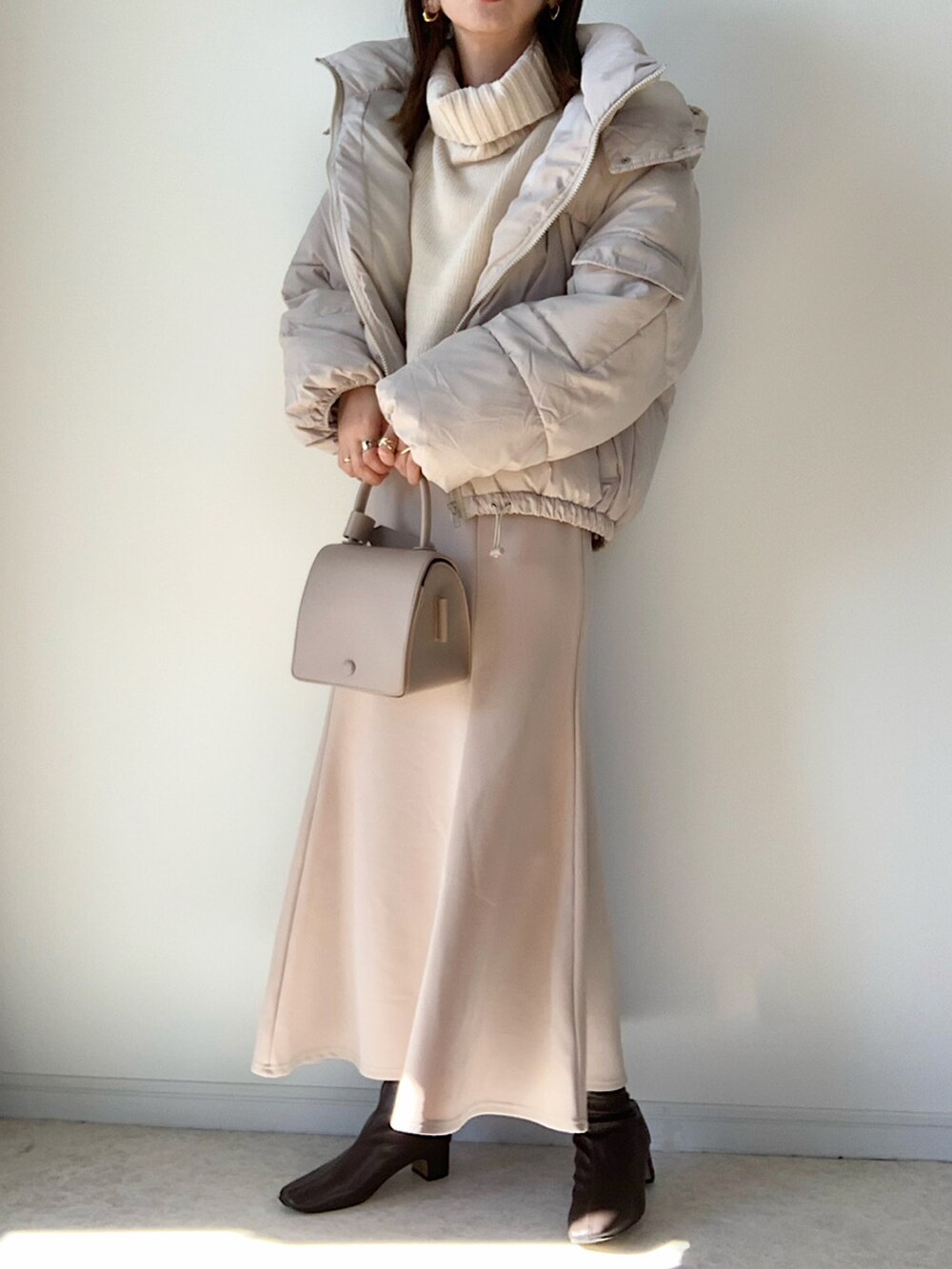 ホワイト系のダウンジャケット/コート、グレー系のワンピース、ベージュ系のショルダーバッグを着用したレディースの秋コーディネートの2枚目の写真